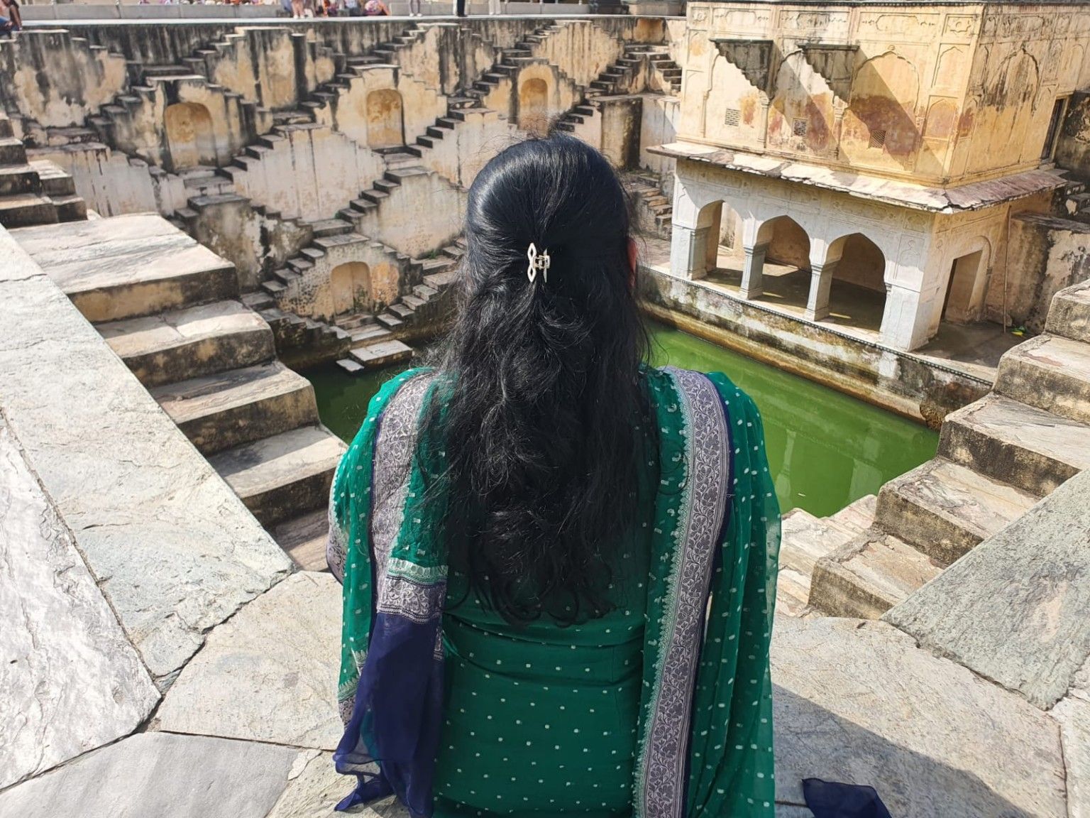 Looking down into the green water of Panna Meena ka Kund stepwell, with its criss-crossing stairs